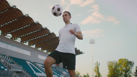 Professional-soccer-player-is-juggling-a-ball.-socker-a-player-in-a-white-football-uniform-at-the-stadium